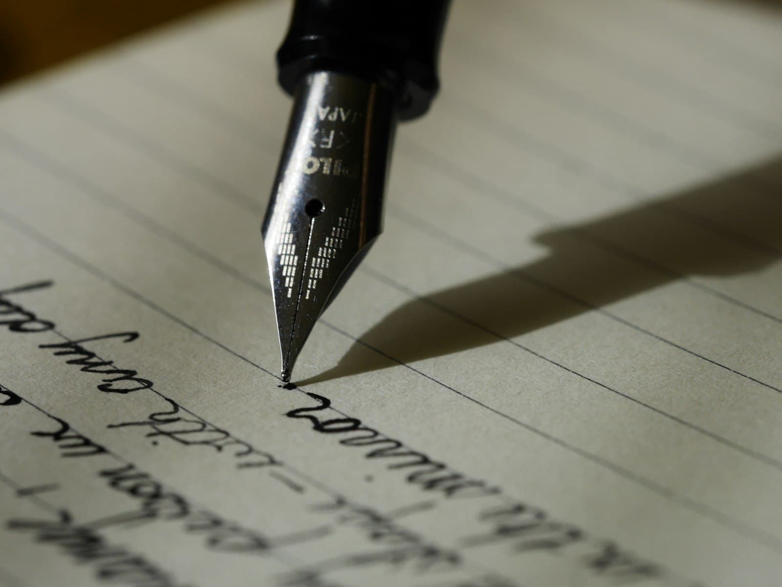 A notebook open on a café table with a pen resting on handwritten notes